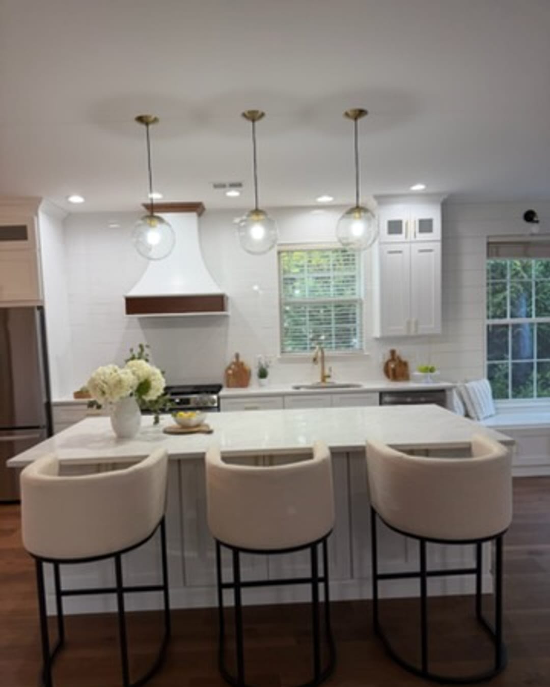 White shaker island kitchen with pendant lights, done