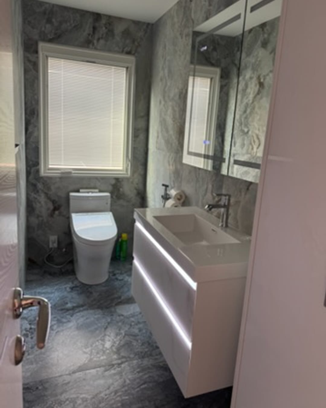 Marble bathroom with LED-lit floating vanity